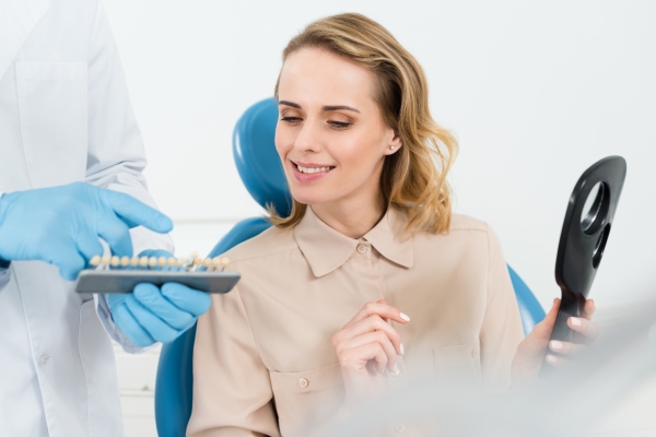 Odontóloga mostrando un modelo dental durante una consulta sobre coronas